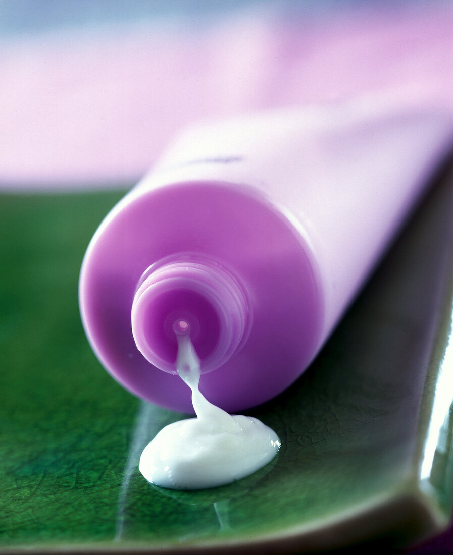Close-up of white cream squeezed out of purple tube