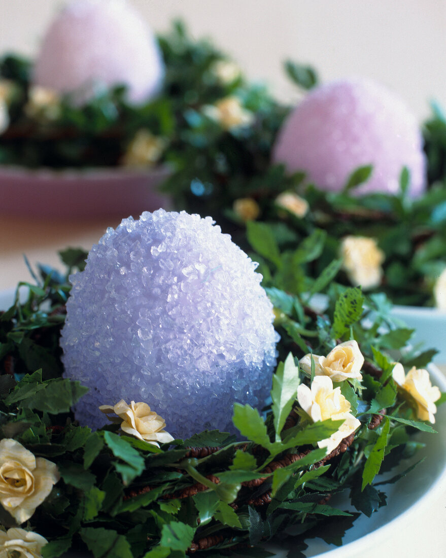 Close-up of plastic Easter egg covered with sugar in verdure nest