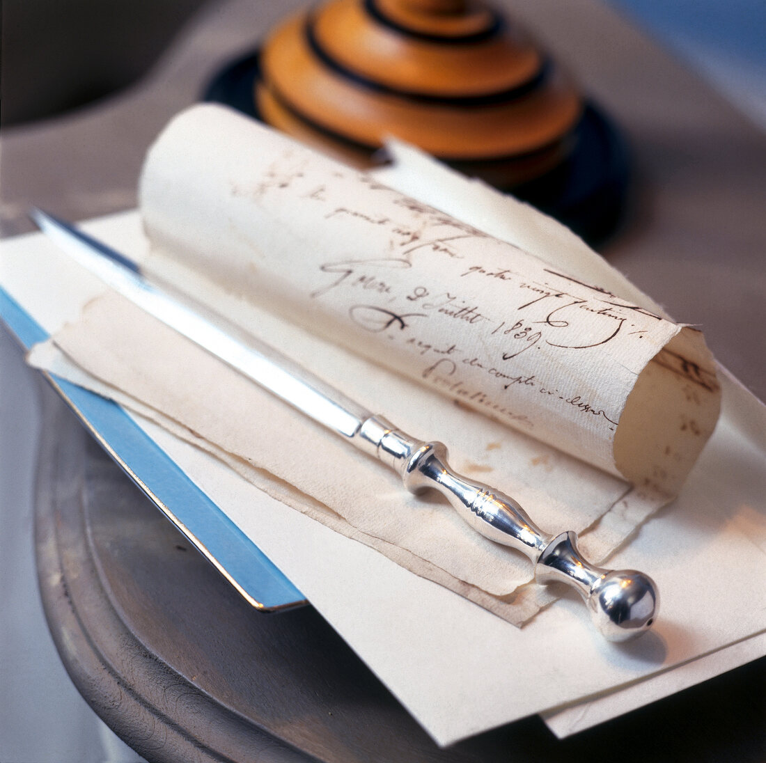 Close-up of silver letter opener on paper with calligraphy text