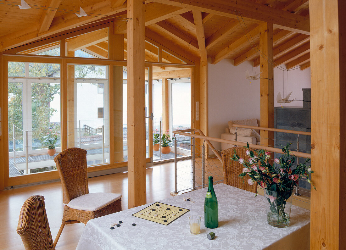 View of living area under wooden roof overlooking winter garden