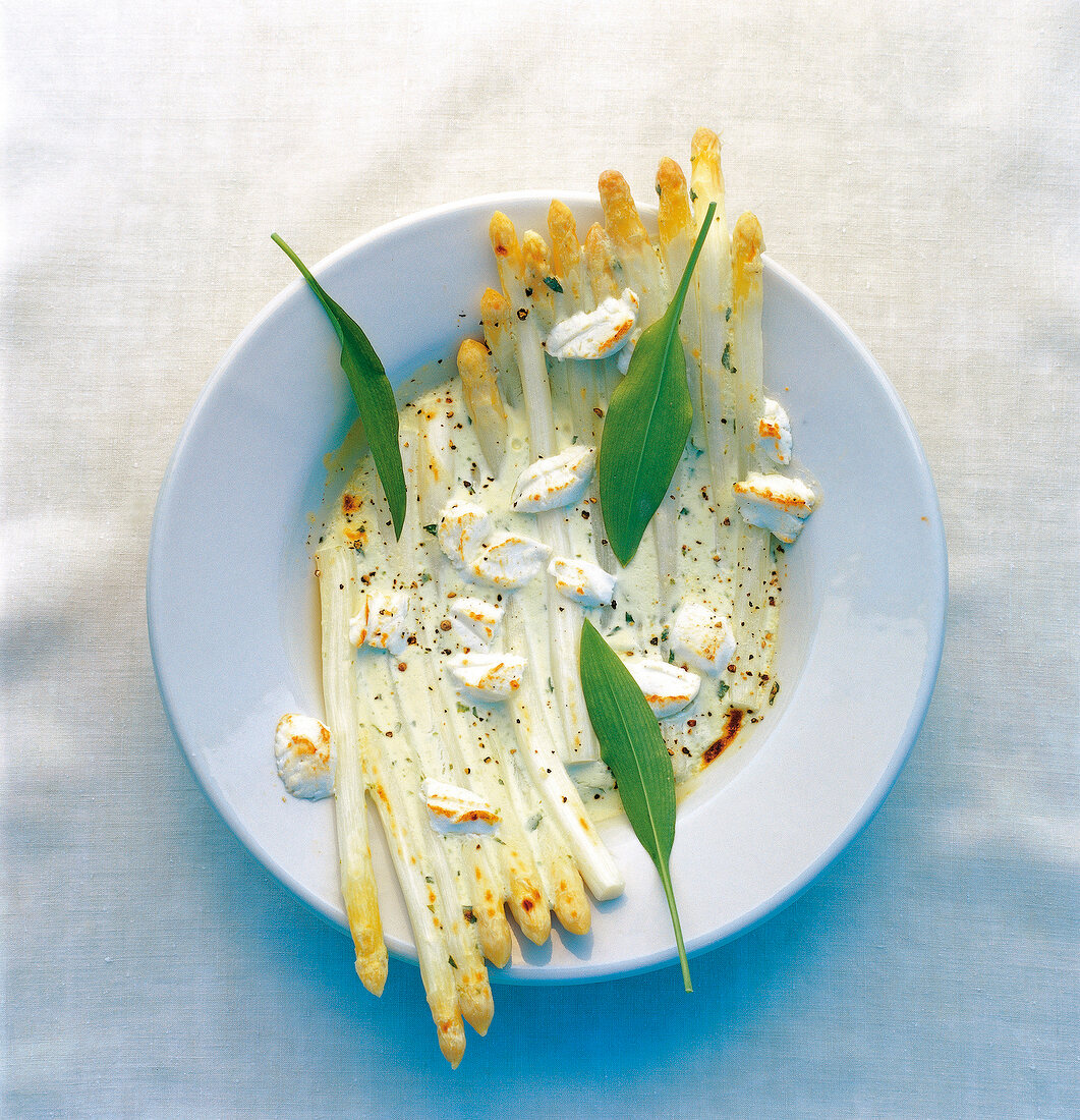 White asparagus with goat cheese, cream sauce and wild garlic leaves