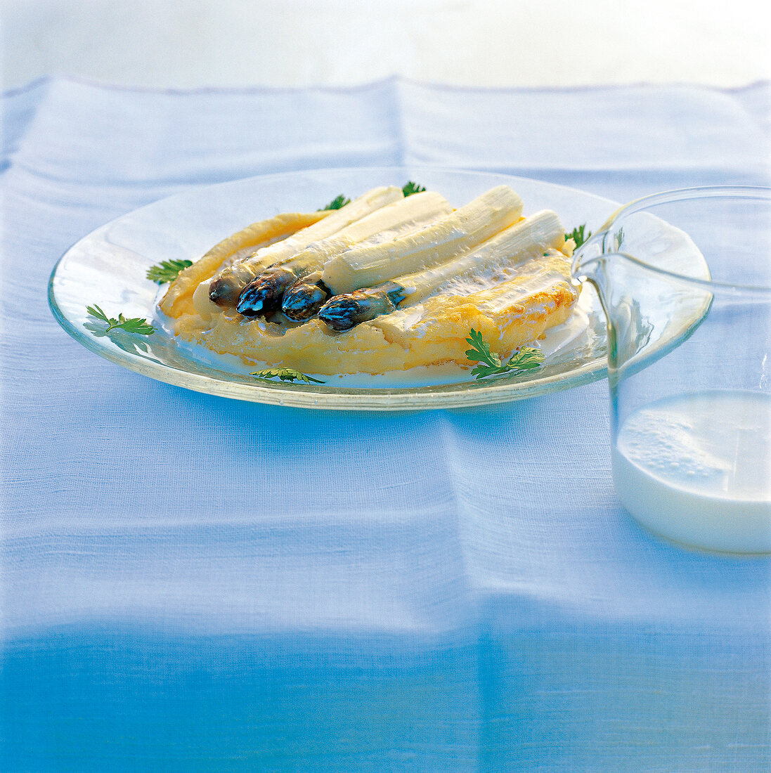 Asparagus clafoutis batter with cream sauce on plate
