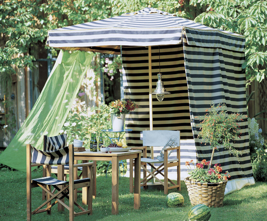 Gartenplatz unter blau-weiß-gestreif -tem Sonnenschirmpavillon