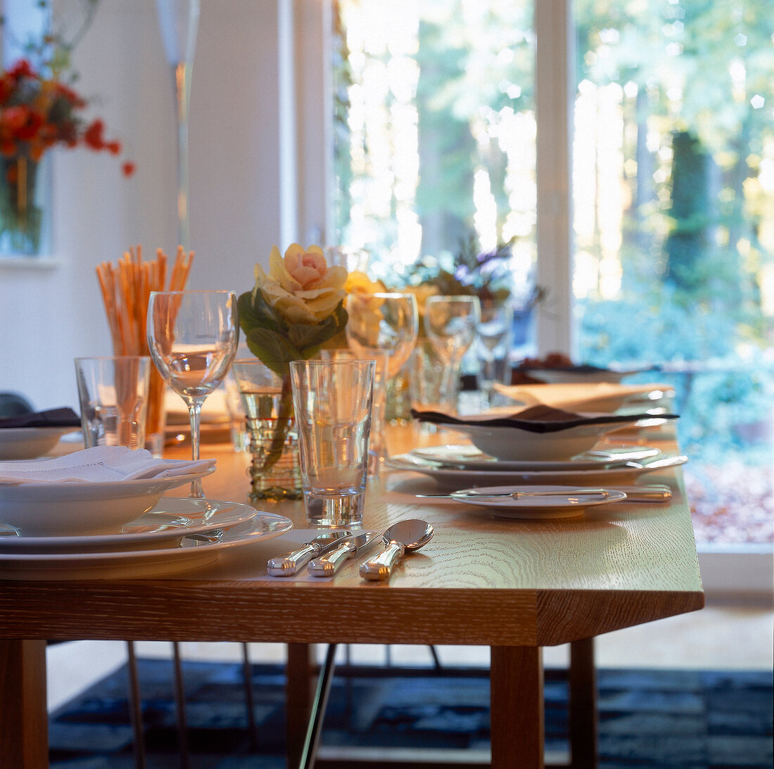 Edle Tafel mit weißem Geschirr + Silberbesteck, Zierkohl in Gläsern