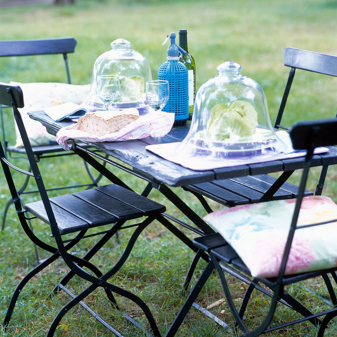 Edles Gedeck für zwei auf urigen, schwarzen Garten-Klappmöbeln