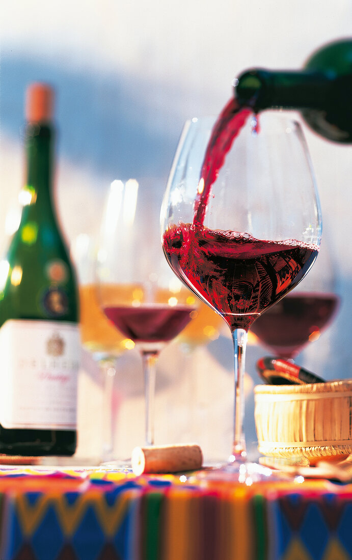 Close-up of red wine being poured from bottle in wine glass