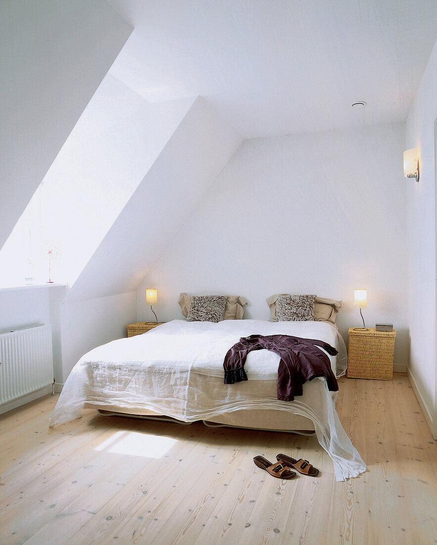 Bett mit Organza-Überwurf unter der Dachschräge