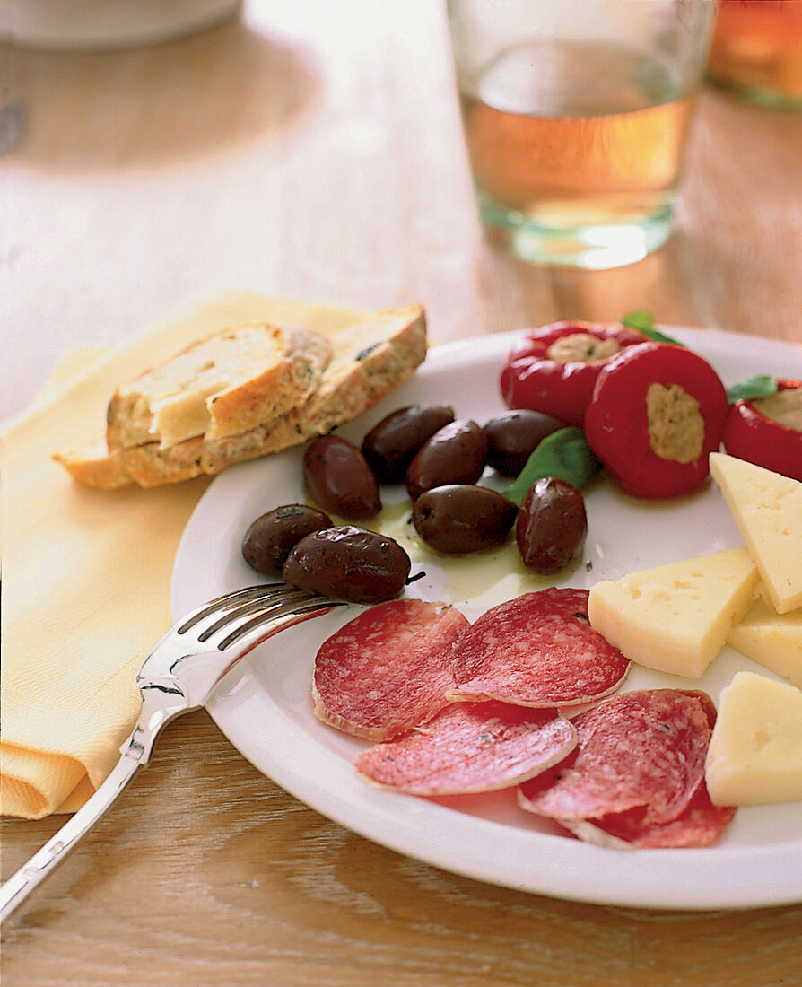 Teller mit Antipasti, Salami, Käse, Oliven, Brot, Tomaten