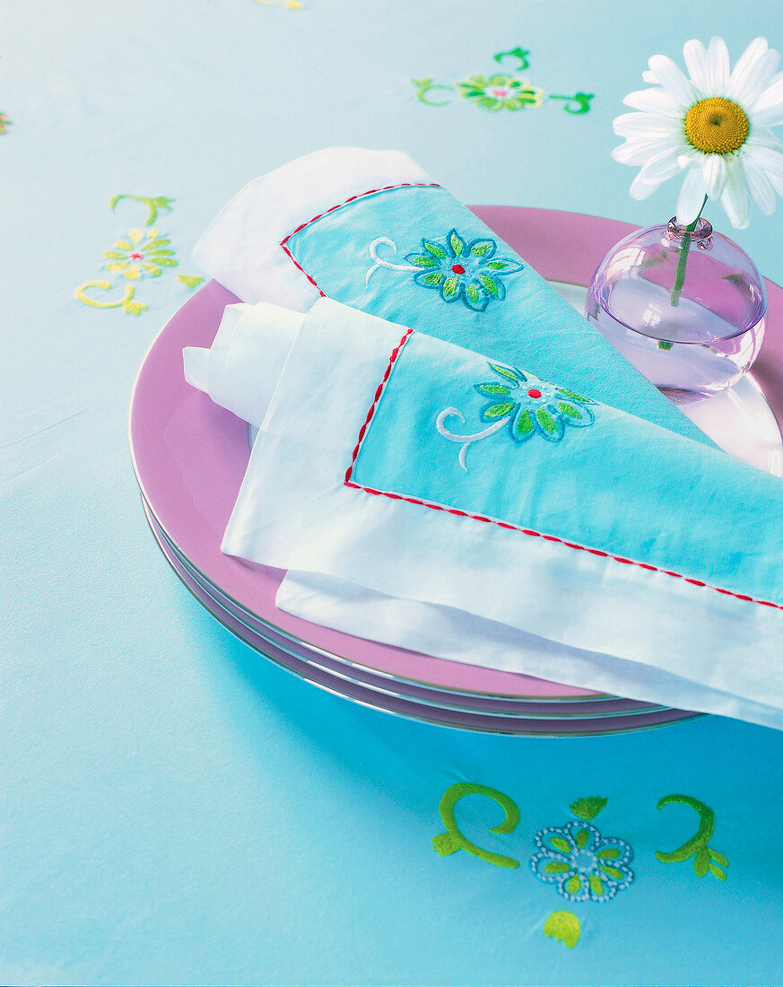 Table linen with embroidery of flower on plate