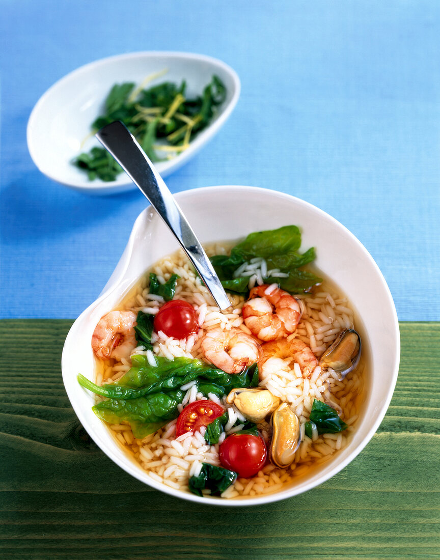 Rice and clam soup with spinach and shrimp on a plate