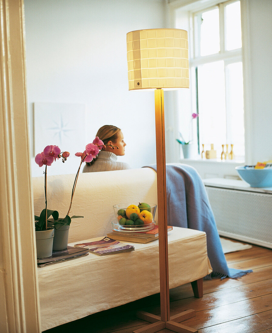 Illuminated floor lamp made of beech wood with white chintz shade in living room