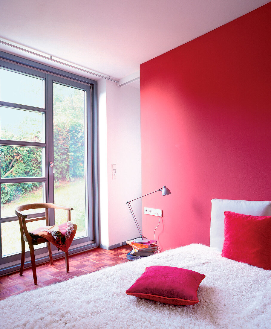 Schlafzimmer, eine Wand rot , weißes Bett mit zwei roten Kissen