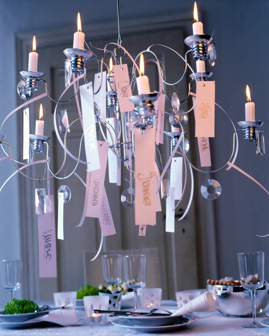 Candle chandelier with glass prisms hanging next to names of all guest