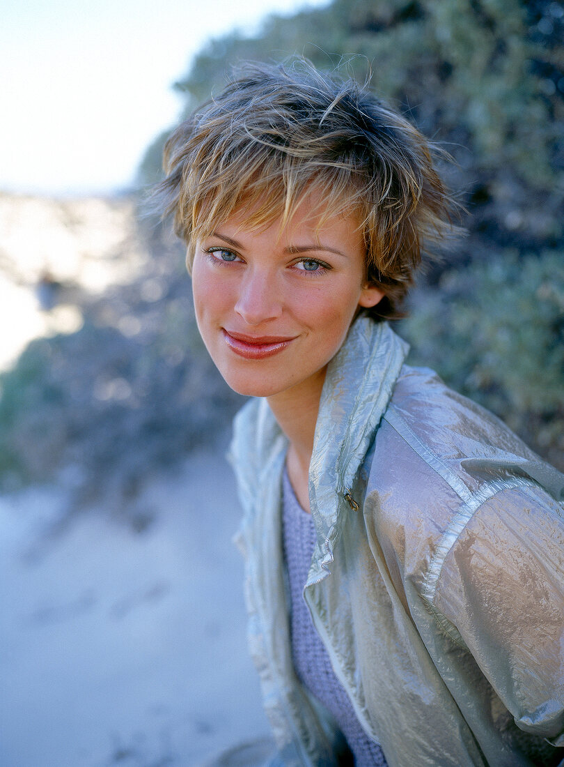 Portrait of pretty woman with short hair wearing jacket, smiling