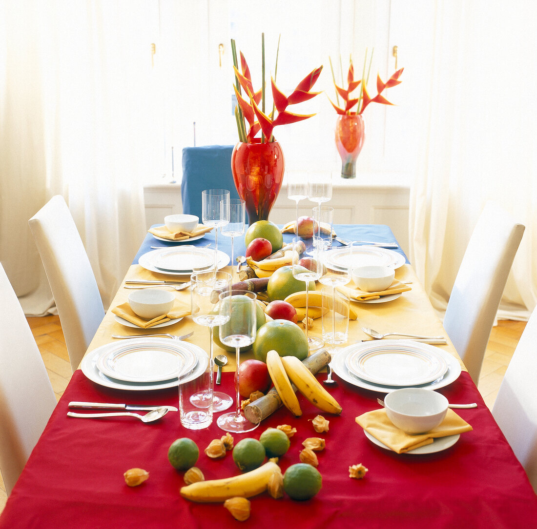 Table laid with white dishes, and fruits decorations