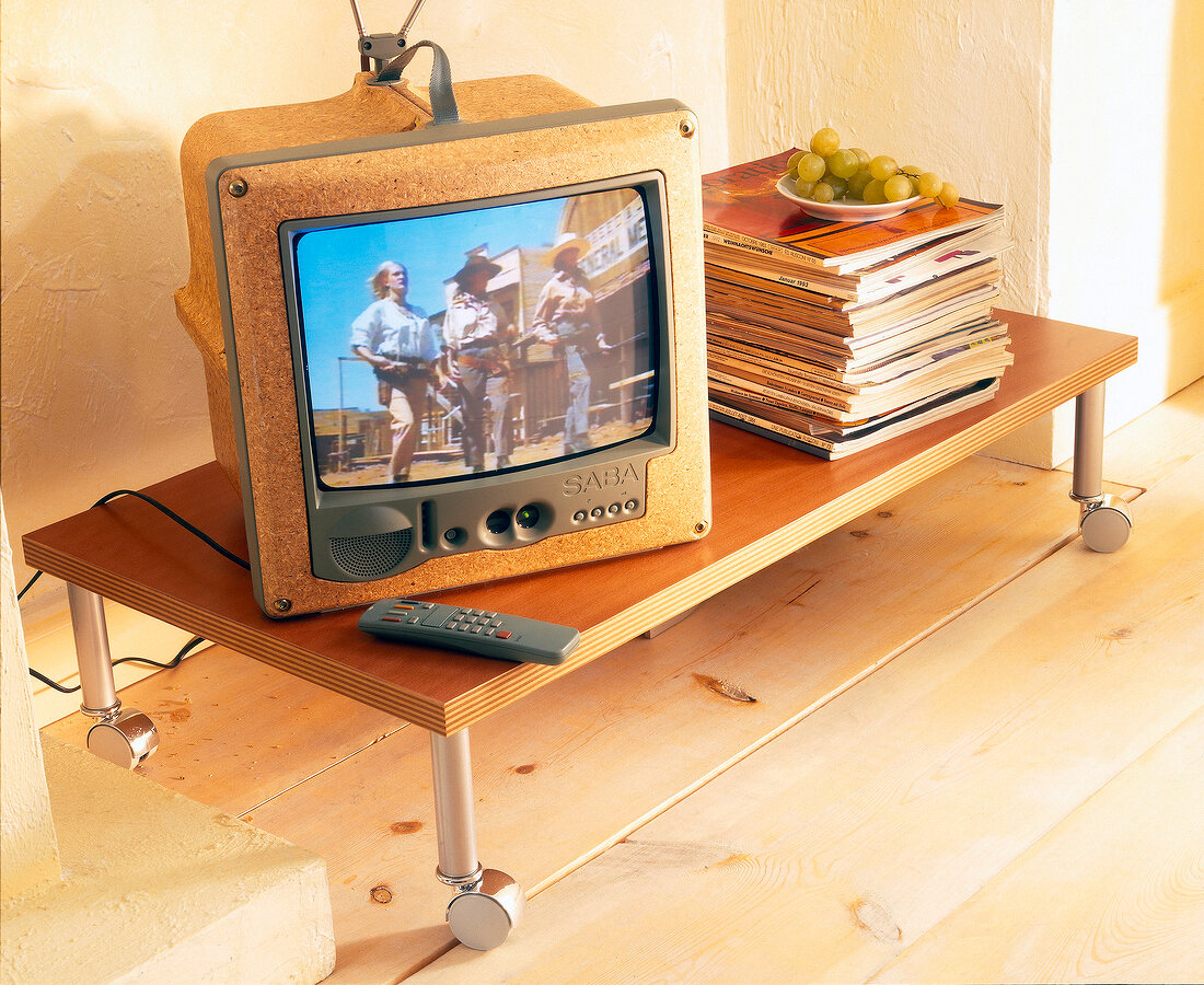 TV and stack of books on wooden wheel table