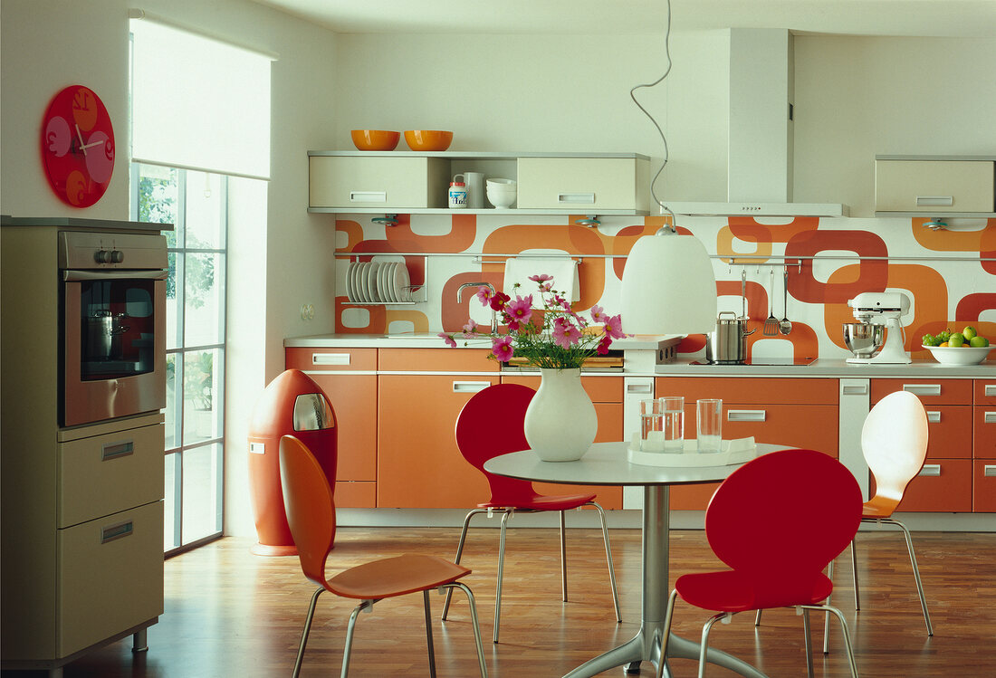 Kitchen in orange and white with round dining table