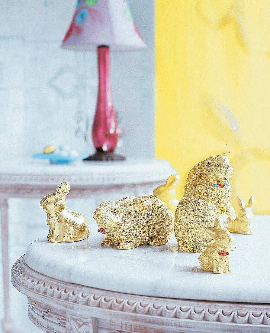 Kleine Häschen aus Porzellan, goldig bemalt, auf einem Tisch