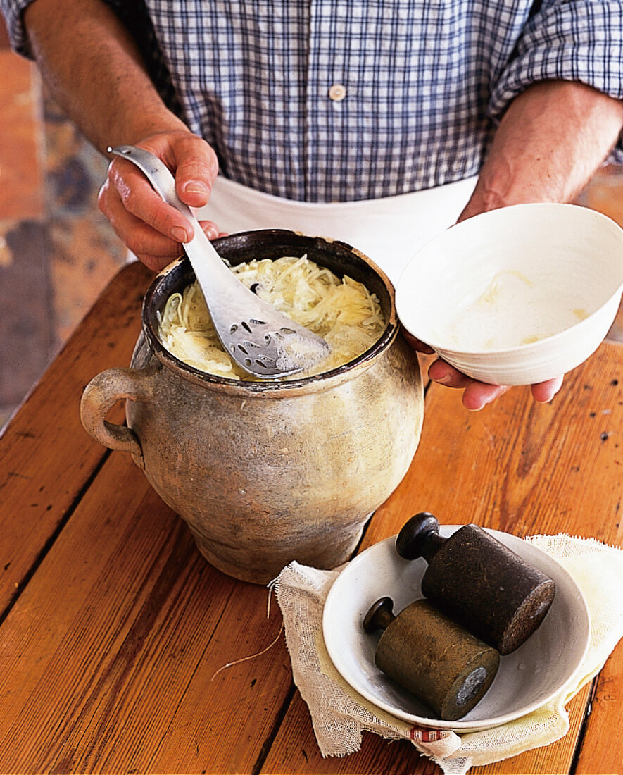 Weißkohl wird für das Sauerkraut mit Gewichten beschwert. Nr. 5