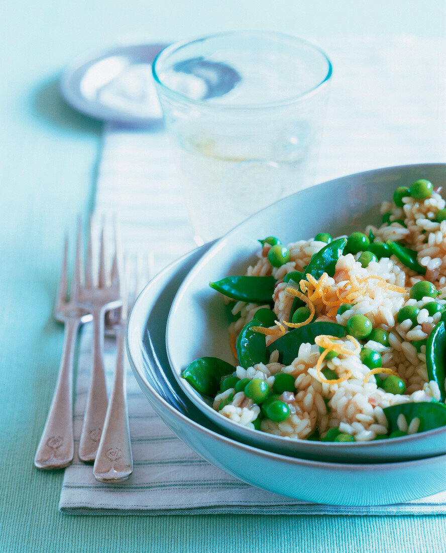 Risotto with peas and mangetout parmesan in ceramic bowl