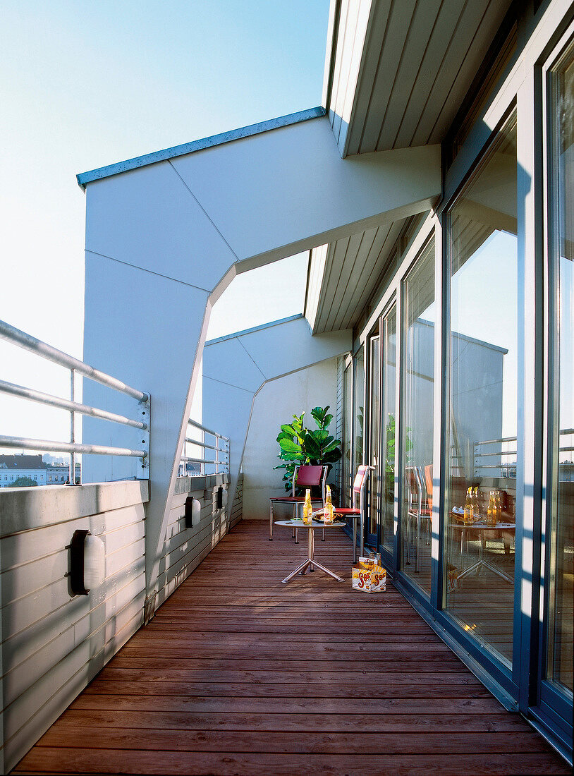 Moderner Balkon mit Holzdielenboden, Stühle, Tisch
