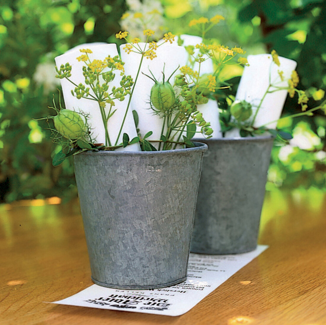 Napkins decorated with fennel blossoms + nigella capsules in a small bucket