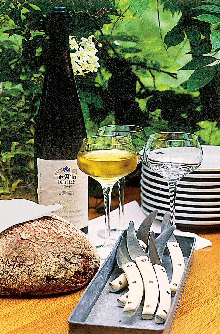 Sauerteigbrot, Geschirr, Besteck, Gläser mit Riesling + Flasche