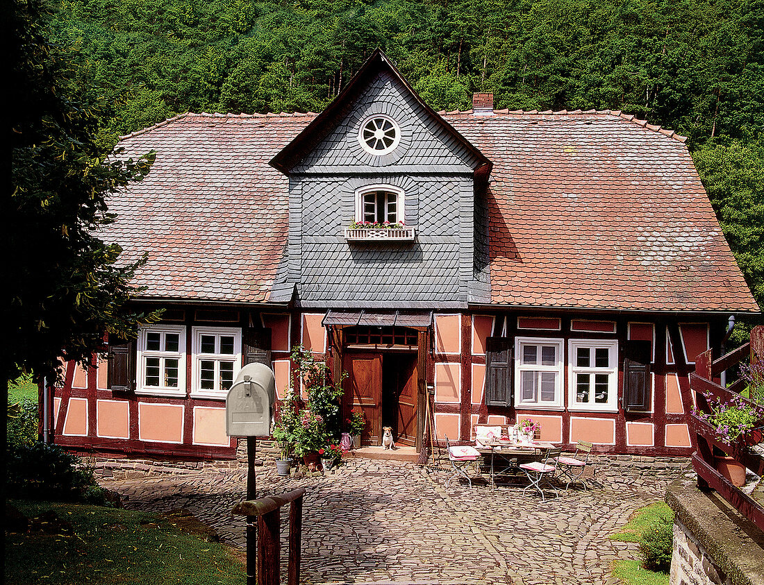 Fachwerkhaus mit Terrasse umgeben von Wald