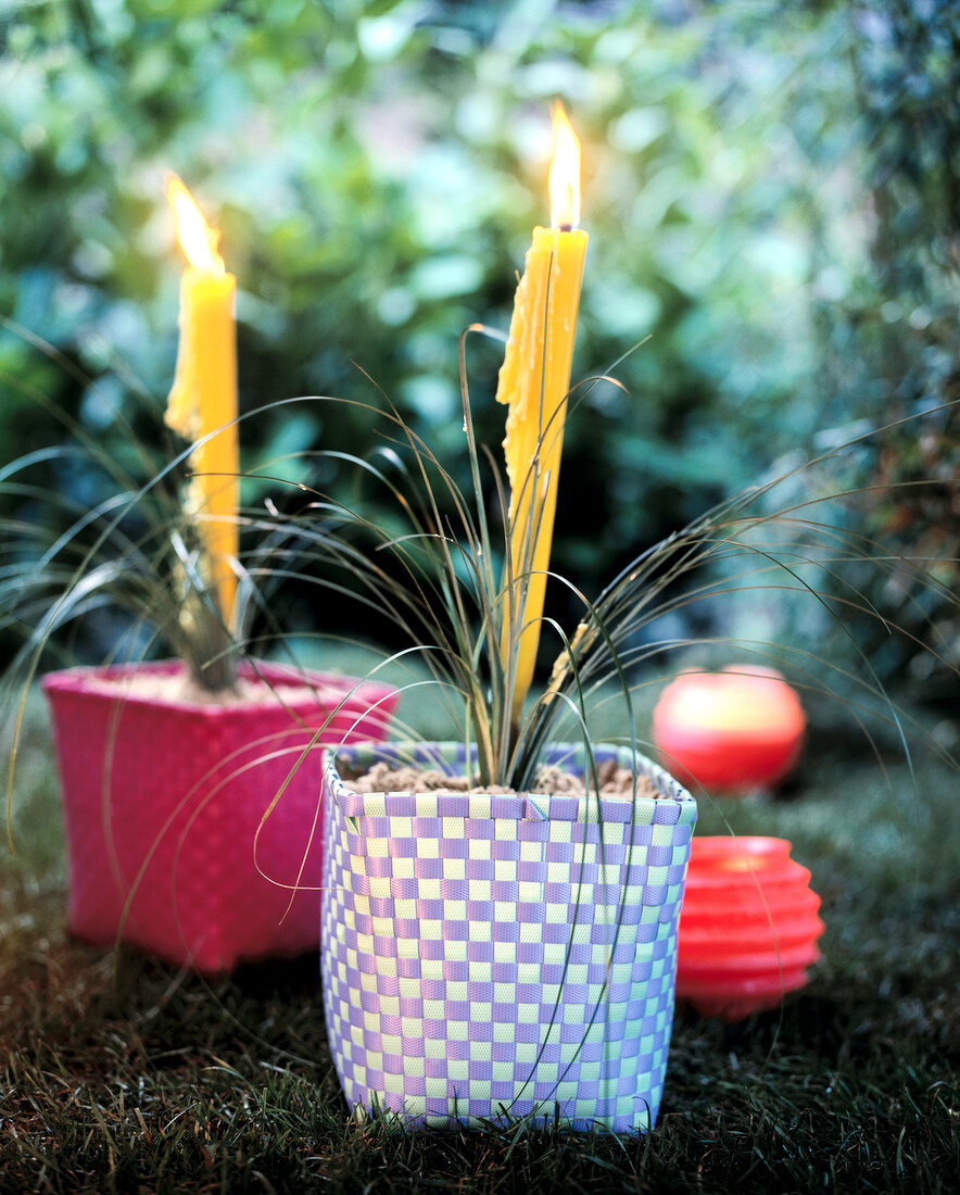 Plugged garden torch and grasses in sand-filled pot