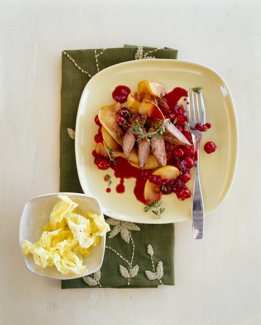 Lamb fillet and apples drizzled with cherry sauce on plate