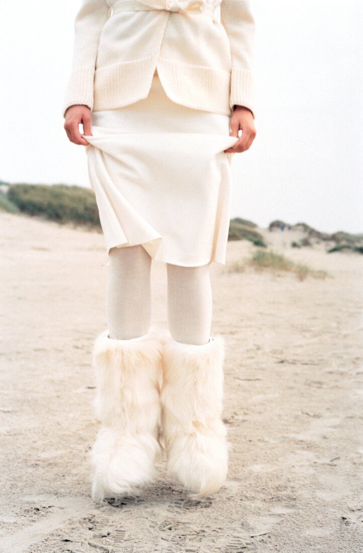 Woman wearing white skirt and fur boots