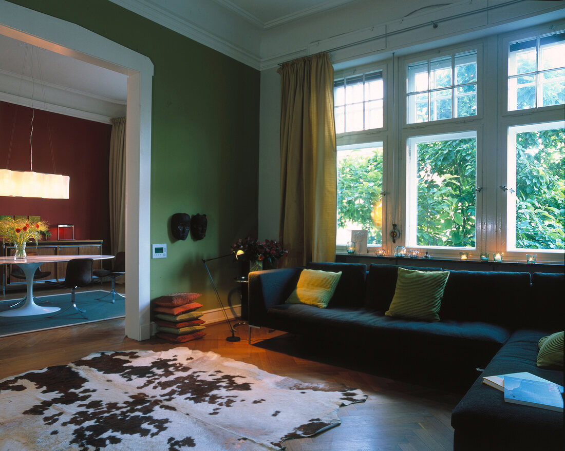 Living room with sofa, green walls and cowhide pattern carpet