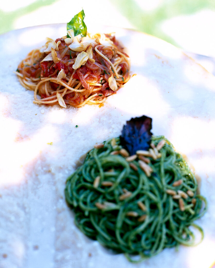 Close-up of spaghetti con pancetta and spaghetti al pesto
