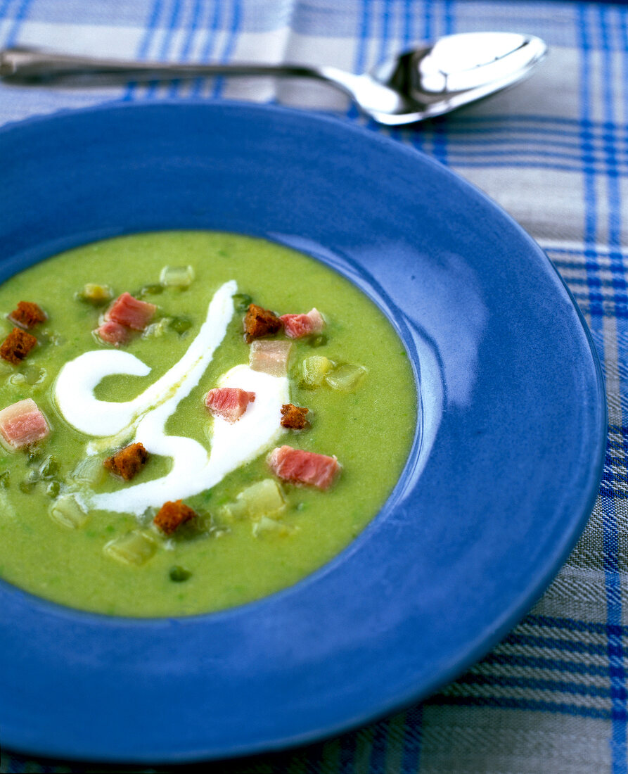 Close-up of green peas cream soup in blue bowl