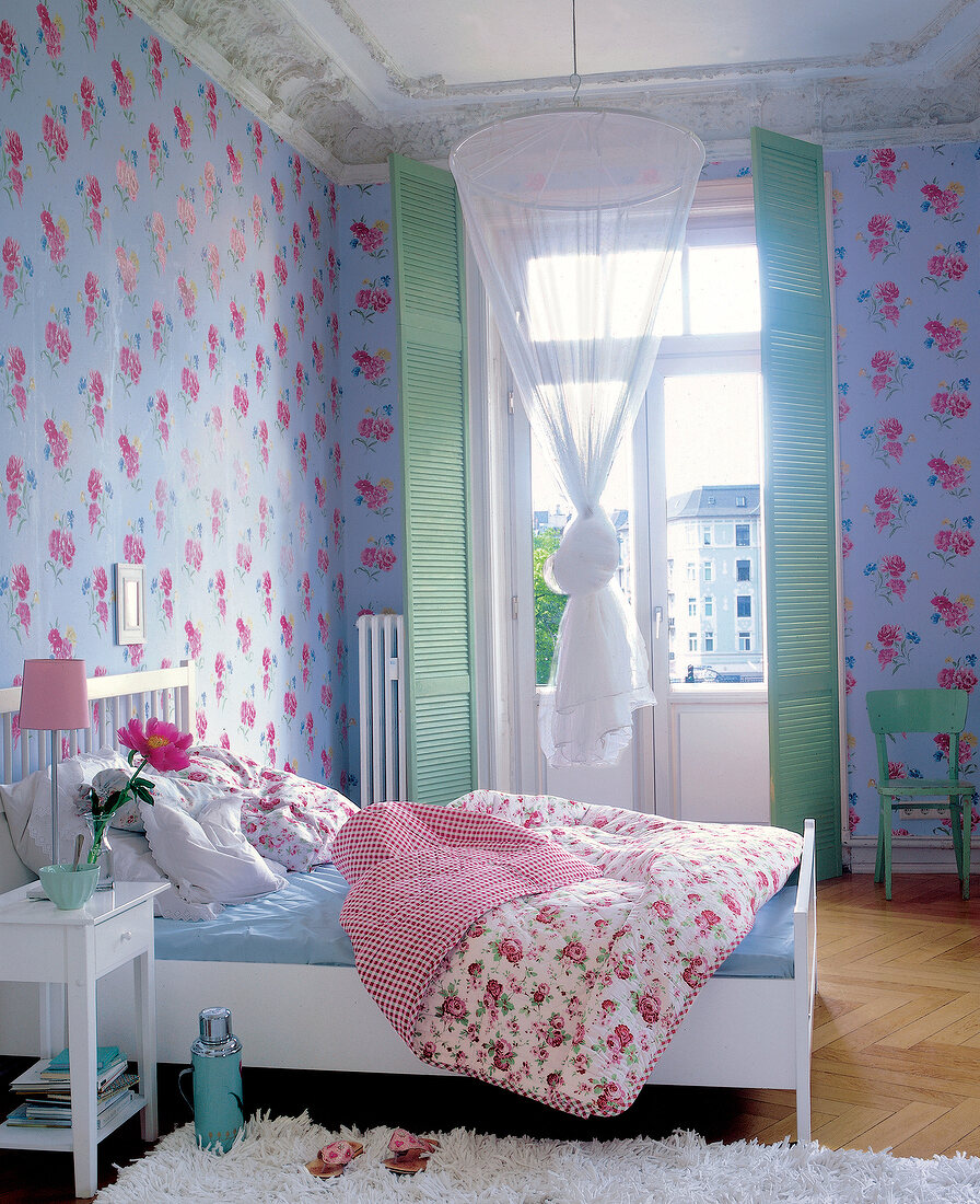 Bedroom with floral wallpaper, bed and door to balcony