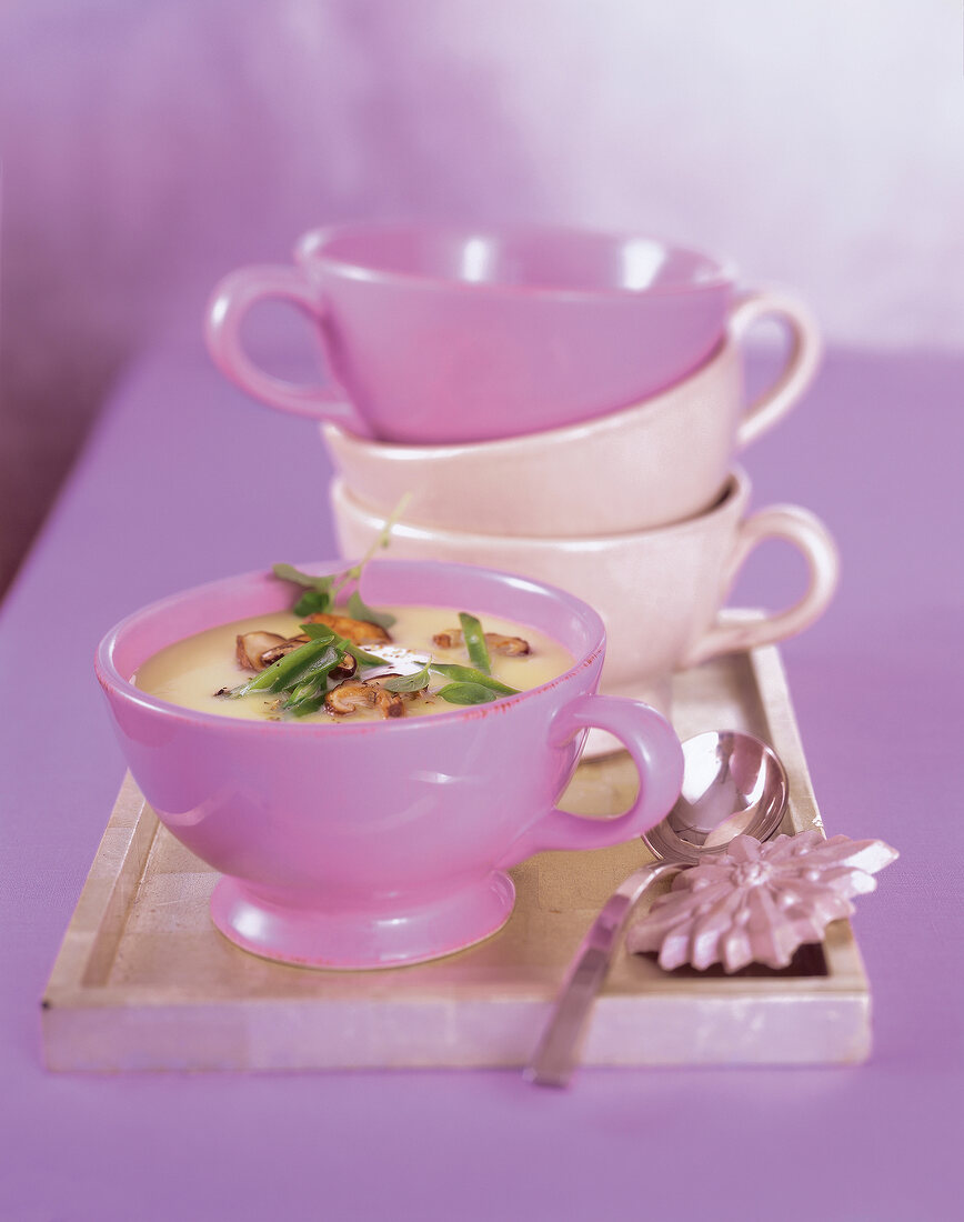 Potato soup with fried mushrooms in pink soup cup