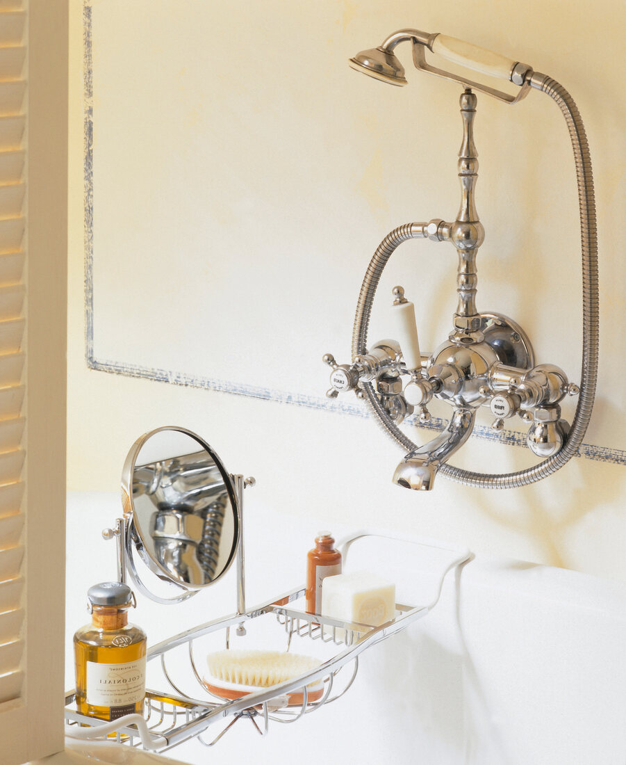 Close-up of silver faucet and hand shower in bathroom