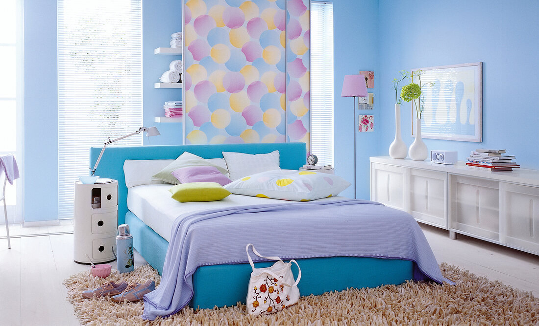 Bedroom with light blue and pastel bed sheet and furniture