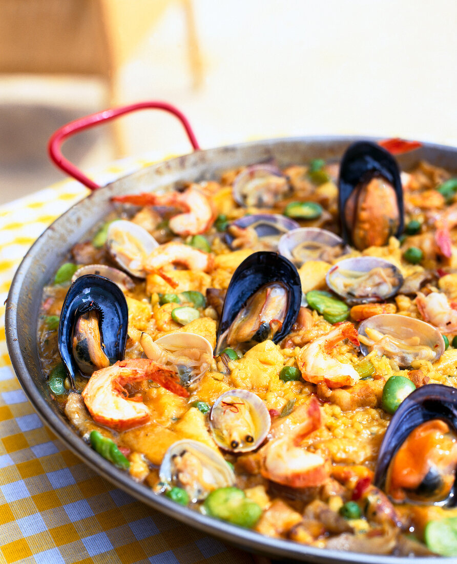 Close-up of prawns, hake and paella with rabbit on pan
