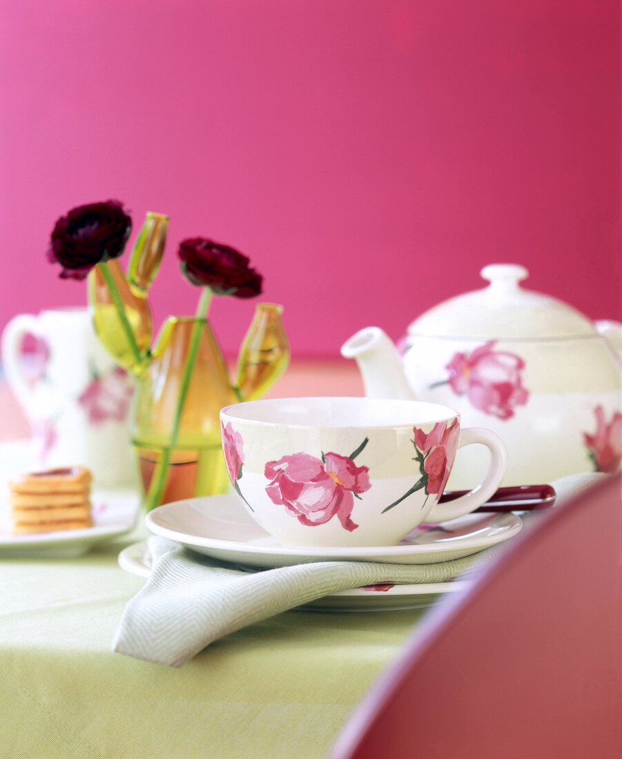 Close-up of teacup and teapot with rose motif