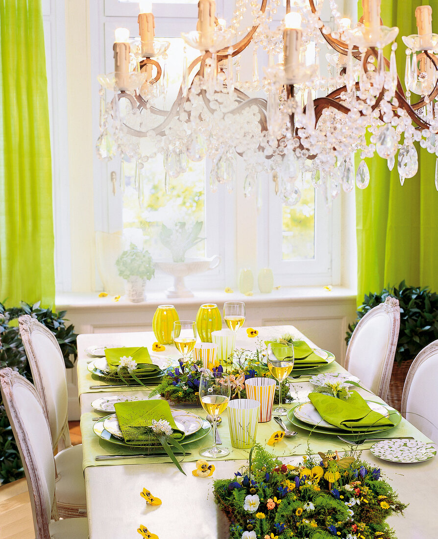Elegant festive table with green decorations and chandelier