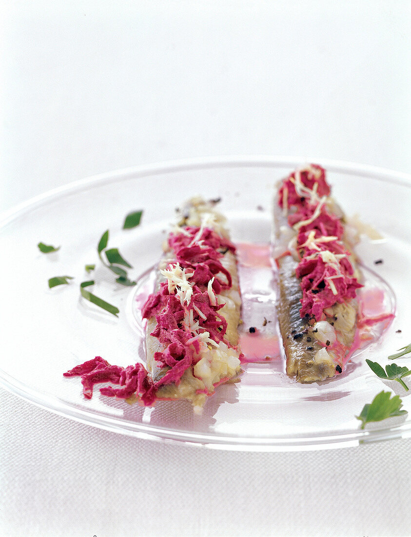 Close-up of marinated smoked herring with beetroot toppings on plate