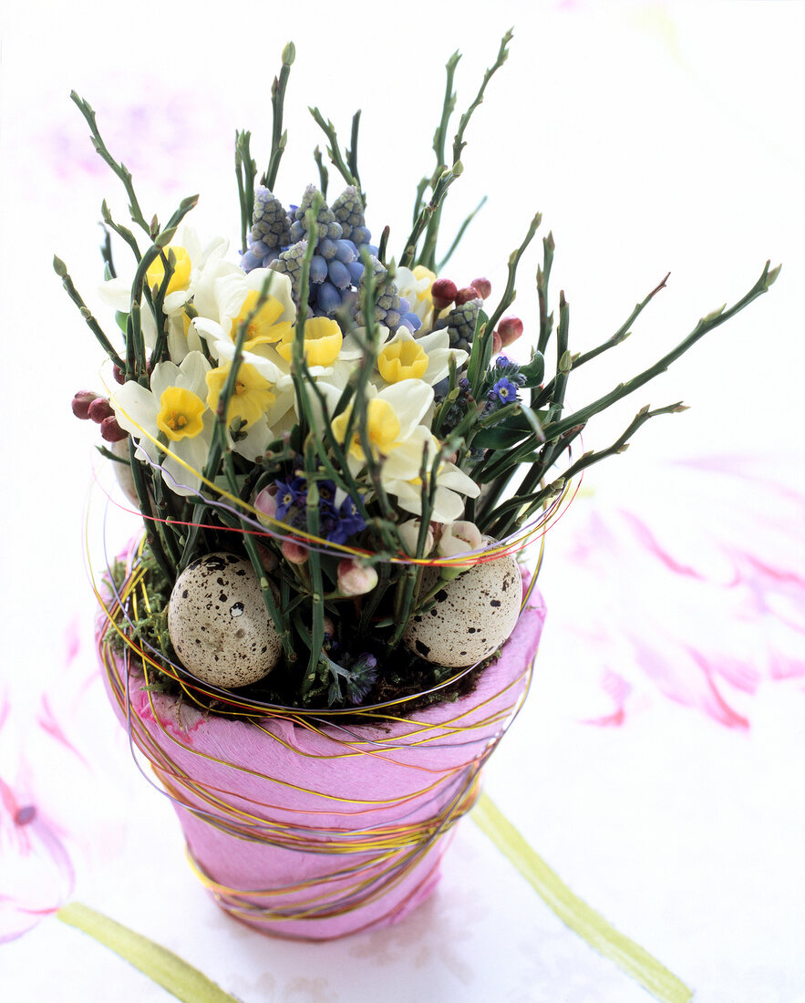 Pot full of spring flowers wrapped in pink crepe and wire