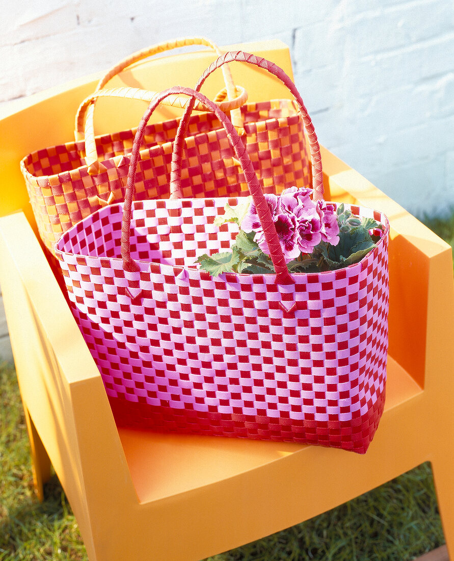 Two colourful neoprene bags with flowers on chair