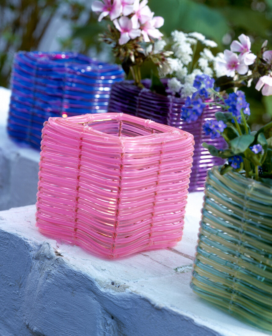 Colourful lanterns made from plastic cord with flowers in it