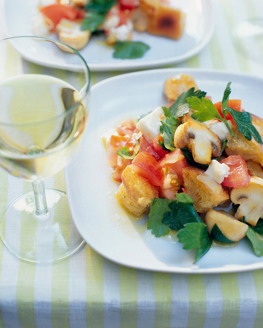 Close-up of bread salad with tomato and mushrooms on plate