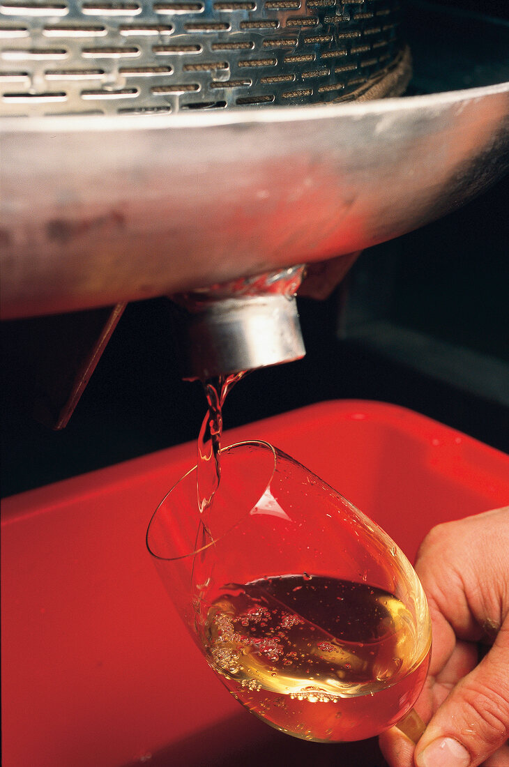 Weißwein, Riesling wird in Weinglas gefüllt, close-up, Detail