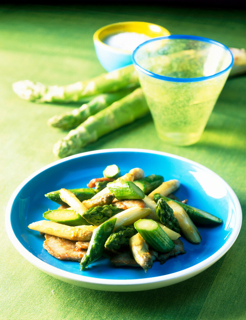 Pfannengerührter Spargel auf blauem Teller