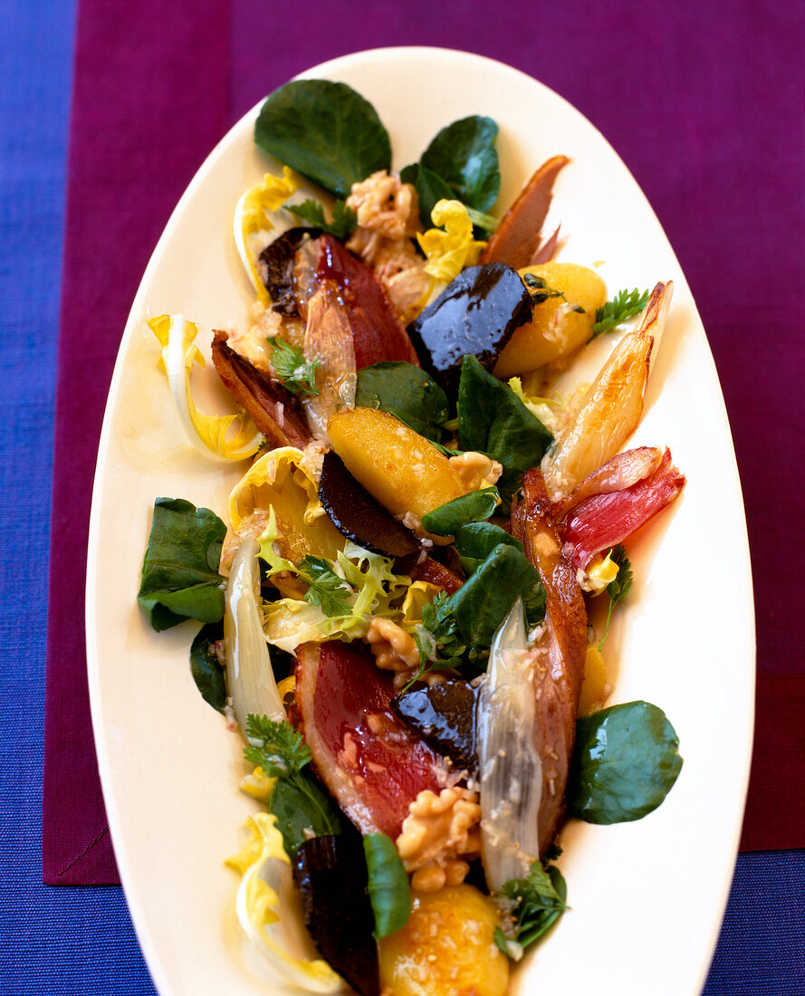 Close-up of salad with duck confit and smoked duck breast on plate