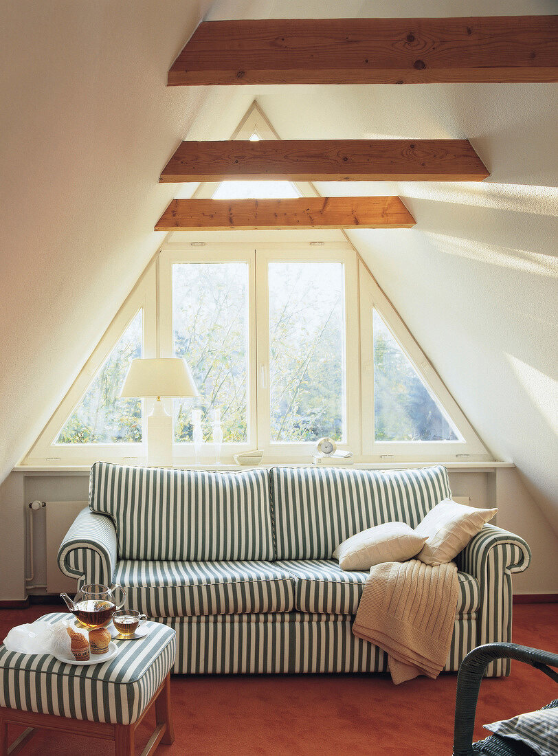 Striped upholstery sofa at the window under wooden roof